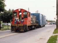 Brantford isn't the only city that has featured street running in the past 25 years. Here's an example. Shown is CN 7724, an SW1200, (off roster by 1990)trundling down the middle of Welland Ave in St. Catharines back on the early eve of July 1, 1987. The stoplight in the background is Niagara St. Trackage has been paved over for many years, but this stretch used to run from the old NS&T trolley yard area just out of sight a block down on the right, and curved off the Avenue left in another 1/4 mile or so, over to the GM plant on Ontario St. Little is left now, as industry retreats from the core of the city as it has everywhere else. GM is gone from this part of the city, but I believe the ol' Duck is still in business. CN 7724 was renumbered from 7024 in 1985 to accomodate switcher rebuild programs.