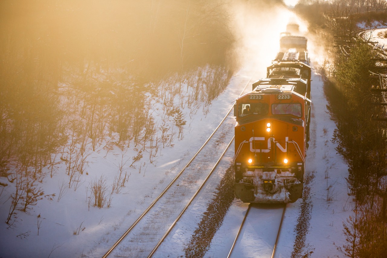 CN 2233 and CN 5609 E kick up some snow on a frosty evening as the sun sets on the CN Strathroy Sub MP 5.8