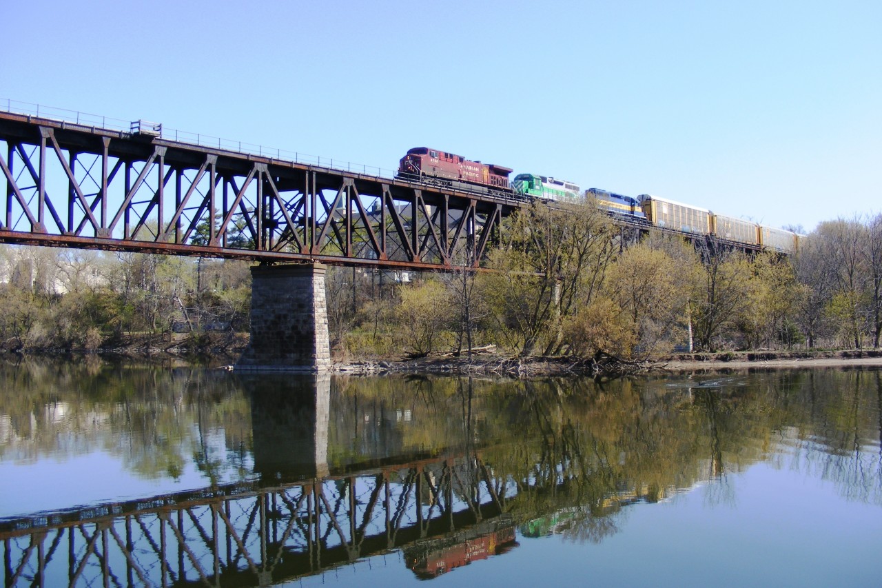 A colourful westbound autorack passes over the Cambridge Grand river viaduct on its way to Wolverton. Viewed from the west riverbank.