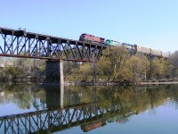 A colourful westbound autorack passes over the Cambridge Grand river viaduct on its way to Wolverton. Viewed from the west riverbank.