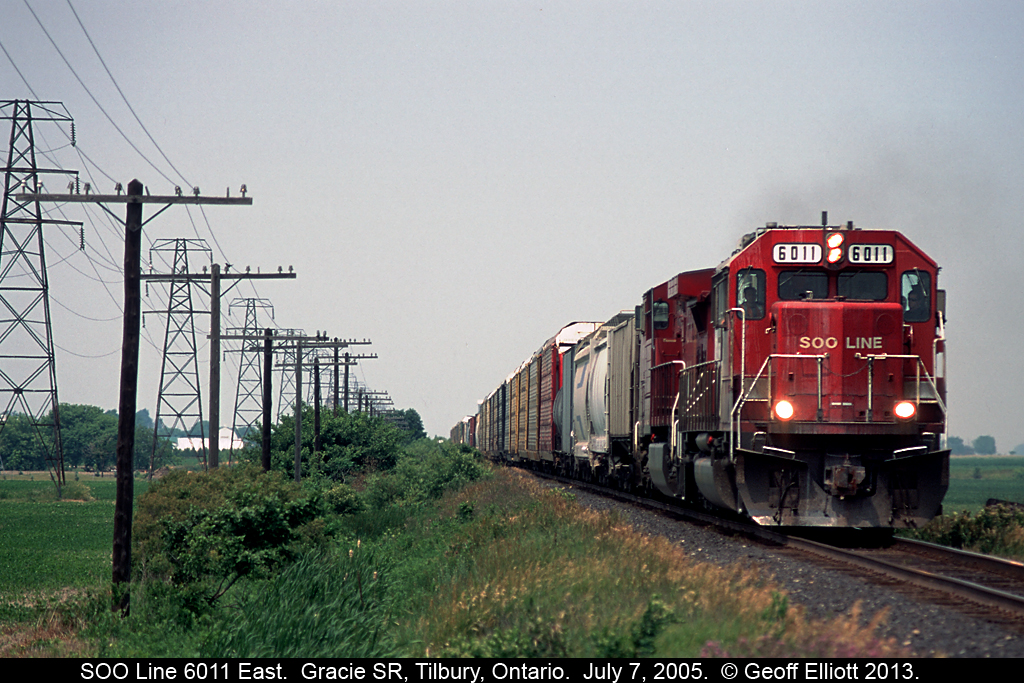 SOO LINE SD60 #6011 and a lone GE have an eastbound rolling fast through the flat land of Essex County on an early July day in 2005.