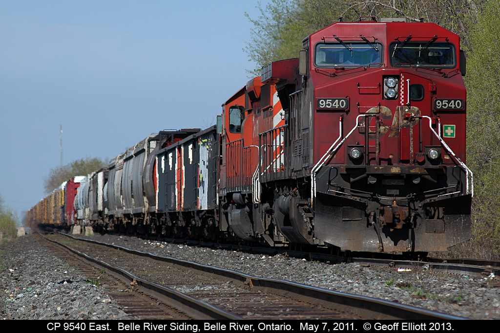 It's a nice hot May day, and CP 9540 and an SD40-2 sit quietly in the siding in Belle River, Ontario waiting for a new crew to take the train east to London, Ontario and beyond.