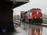 12:15 on a very wet Sunday, train 148 an eastbound intermodal picks up speed as it drives on through the rain!