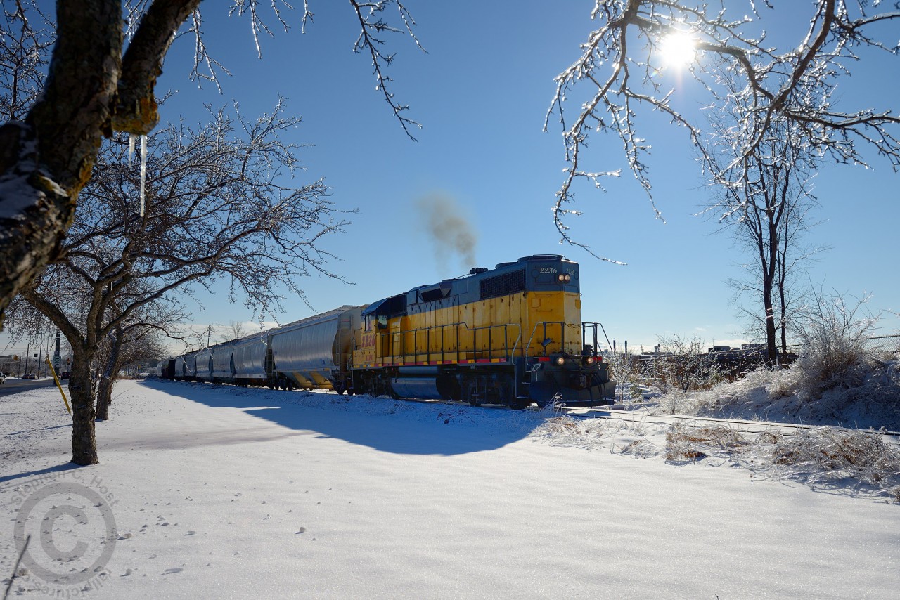 Christmas eve has arrived and I was given a couple early presents: Work let us out early - and mother nature gifted me sunshine. Among the glistening ice-covered trees, LLPX 2236 lets out a puff of exhaust as it limbers to work Guelph.