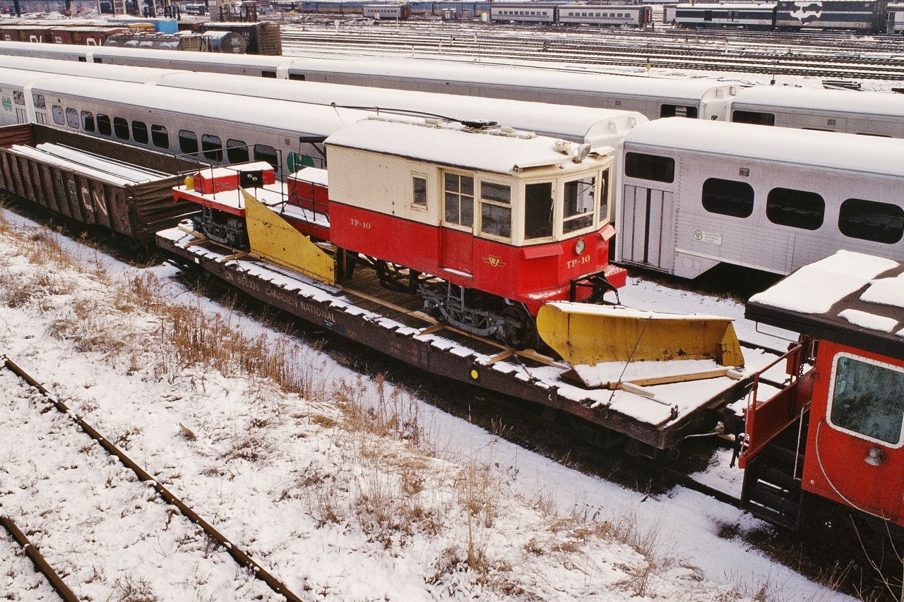 December 1978, T.T.R. North Storage tracks (north of the main, west of Spadina), 


On the flat car:  TTC Track Plow # 10 is ready for shipment to Saint-Constant. (Trackside Guide reports unit stored indoors - not on display).


( the Trackside Guide records ex TTC  TP-11 (NSC 1945)  at the Halton County Radial Railway).


In the background, at the CN Spadina Coach yard:


1) Two ( 2 )  Northlander train sets – Werkspoor TEE powered!.


2) ex CN Tempo equipment in Via colours – this equipment is now the Algoma Central tour train (formerly D&RGW Ski Train).


3) CN 'Car- Go – Rail' box car in CN passenger livery – a regular attachment to the tail end of the daily Super Continental


4) Hawker Siddeley built single level GO Transit equipment on the adjacent T.T.R. North Storage tracks.


December 1978 Kodachrome by S. Danko