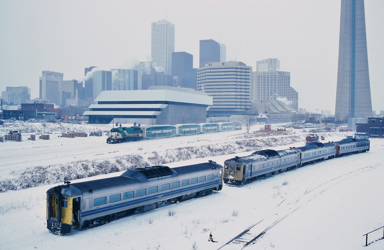 Winter in the City.


The View from the Spadina Avenue bridge.


Once upon a time one only traveled downtown to see the servicing of mainline passenger power and equipment.


The Go consist was typical for weekend service.


And Go Transit – like the new (at that time) Via Rail – made use of used power: that GO engine was originally a Rock Island unit and the control cab (ACPU) formerly an O.N.R. FP7A.


The triple Budd car lash-up is likely for a 600 series train: either the Niagara Falls (next out #641) with two return Budds daily ( plus the Maple Leaf) or the London (next out #665) back (north) route (Weston – Guelph Subs) with five return Budds daily ( the International was a Dundas Subdivision train ).


At right, above the last Budd car -  what I have been told – is the Spadina roundhouse load test platform, part of a C Liner unit.


To the right of the Go ACPU, in the corner of the parking lot is the CN community caboose on pneumatic tires.


At the right centre background note the T.T.R. John Street tower has a roof ! Soon to be removed to accommodate the new Sky dome access bridge from Front Street.


The building prominent centre is the new RBC data centre.


January 25, 1985 Kodachrome by S. Danko.


More Spadina views: 


 foreign power  


 classic  


 different angle  


 contrasting cabs  


sdfourty