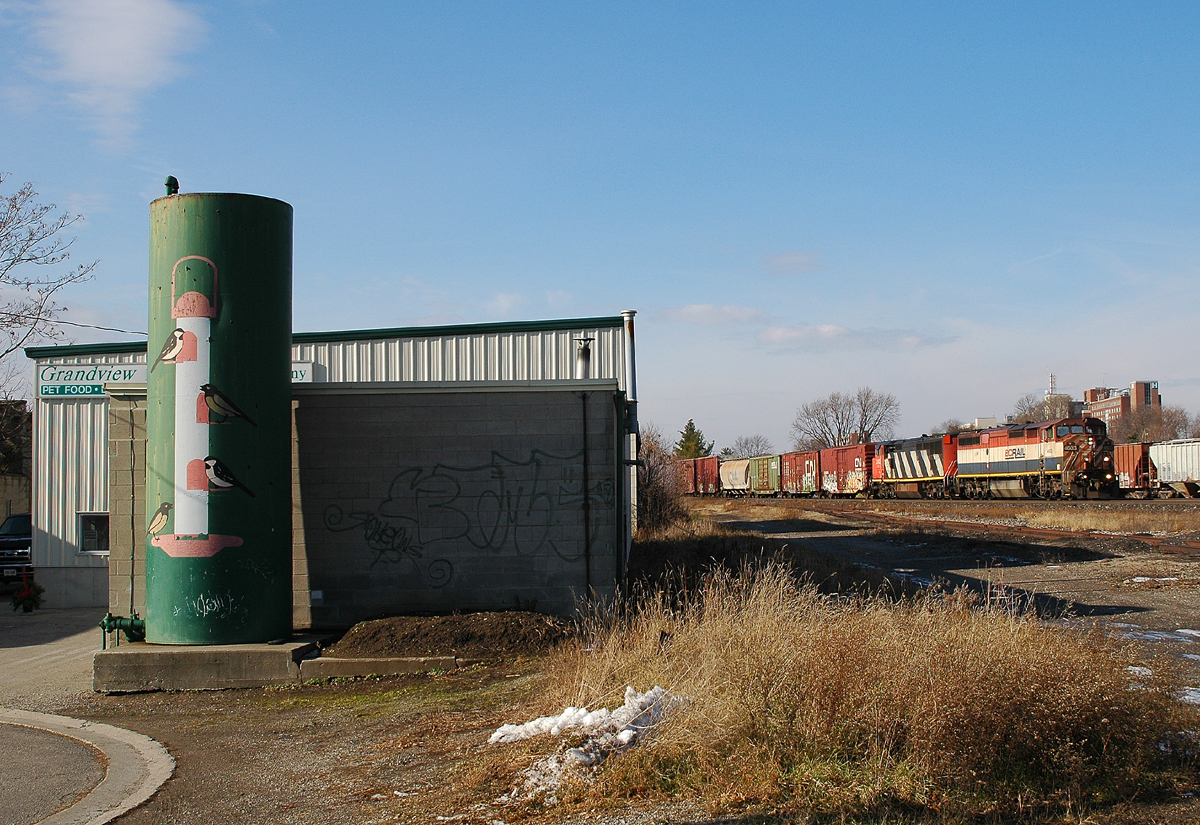 332 With a pair of GE C40-8M's (BCOL 4603 - CN 2402)descend the grade into Brantford with a CAT 349E on a flat car 15 or so cars behind the power