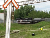 Working the north end of Orangeville (south of where the line to Owen Sound ends and was ripped up by the CPR), Orangeville Brampton Railway's once sole power CCGX 1000 switches tanks at PolyOne Canada, one of the few industries on the OBRY. The crossbucks mark a road crossing of the spur pictured, that once lead to customers in another industrial area. <br><br> The 36 mile rail line was purchased by the Town of Orangeville in 2000 when the CPR was about to abandon it (and subsequently rip the rest of it up), which would have impacted a number of industries and jobs in Orangeville that relied on the railway as a competitive means to ship their products. Since day one, Cando Contracting has operated the line for the town, which includes supplying their own power and switching out the roughly half-dozen customers in Brampton and Orangeville on a biweekly (twice a week) basis.