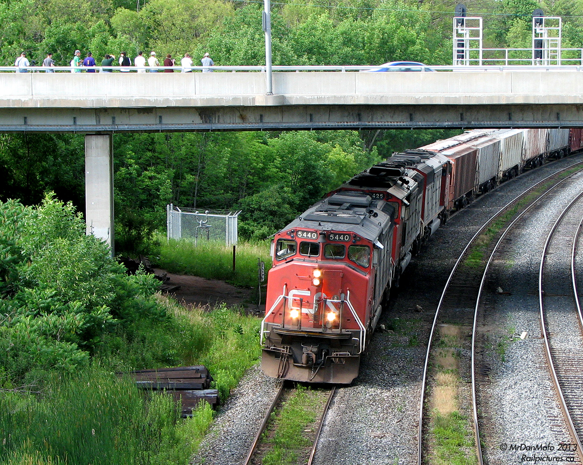CN #393 makes a run for the hill at Bayview Junction, rolling west under Plains Rd. bridge with a nice matching trio of "Zebra Barns": GMD SD50F's 5440, 5425 and SD60F 5559. The dozen or so armed-with-camera railfans that just shot the train are there for the annual Bayview Meet, with a good 3/4 of them pictured also being RP.ca contributors. It might be tricky for some to name all 12 correctly however...