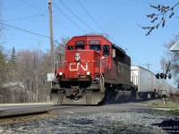 <i><b>Beat the Rush.</b></i> <br><br> CN train 145 "The Roadrailer" beats the evening GO train rush as it rolls through the single track territory of the busy CN Halton Subdivision, minutes before the first scheduled GO train is due in downtown Brampton. Once the GO rush hits full swing, the Rail Traffic Controller must juggle a steady flood of half hourly westbound GO and VIA trains coming from the south track at Bramalea, through the single track between Peel to Brampton East, on to the north for Brampton Station, through the single-tracked Credit River bridge and into the GO commuter compound at Georgetown. All the while trying to manage various eastbound and westbound CN through-freights on the same tracks, the occasional local out switching, and that kooky <a href=http://www.railpictures.ca/?attachment_id=6673><b>GEXR 431/432</b></a>. <br><br> The Triple Crown Roadrailer, made up of somewhat boring truck trailers designed to ride on rail bogies, has always warranted precisely one unit. This one unit is often a wildcard from day to day, ranging from a clapped-out rusty GP40-2W, a well-worn secondhand or rebuild SD40, a ho-hum GE -9W, to a brand new SD70M-2. Today it's one of CN's 29 rebuilt SD40u units (or SD40-2Q, or SD40-3, or GF-630a, whatever!) kicking up crossing dust over James St. The lucky Batman sign scribbled on its front pilot must be giving it an extra bit of good luck today. <br><br> Hard on his heels is <a href=http://www.railpictures.ca/?attachment_id=10026><b>GO #281</b></a> "The Bramalea Flip" - the afternoon 7-car GO train that ping-pongs between Bramalea and Toronto Union, which makes its final trip all the way to downtown Brampton to kick off the flood of evening GO trains. In only 3 minutes, the green and white train will zip into view and begin slowing for the station. <br><br> Today, the SD40u's have been rebuilt for yard service, half of the James-John St. crossing has been closed, the single-track juggling has been eliminated with double-tracking and platforms on both sides of the tracks, and the afternoon GO train has been temporarily cancelled. But at least the Roadrailer still runs.