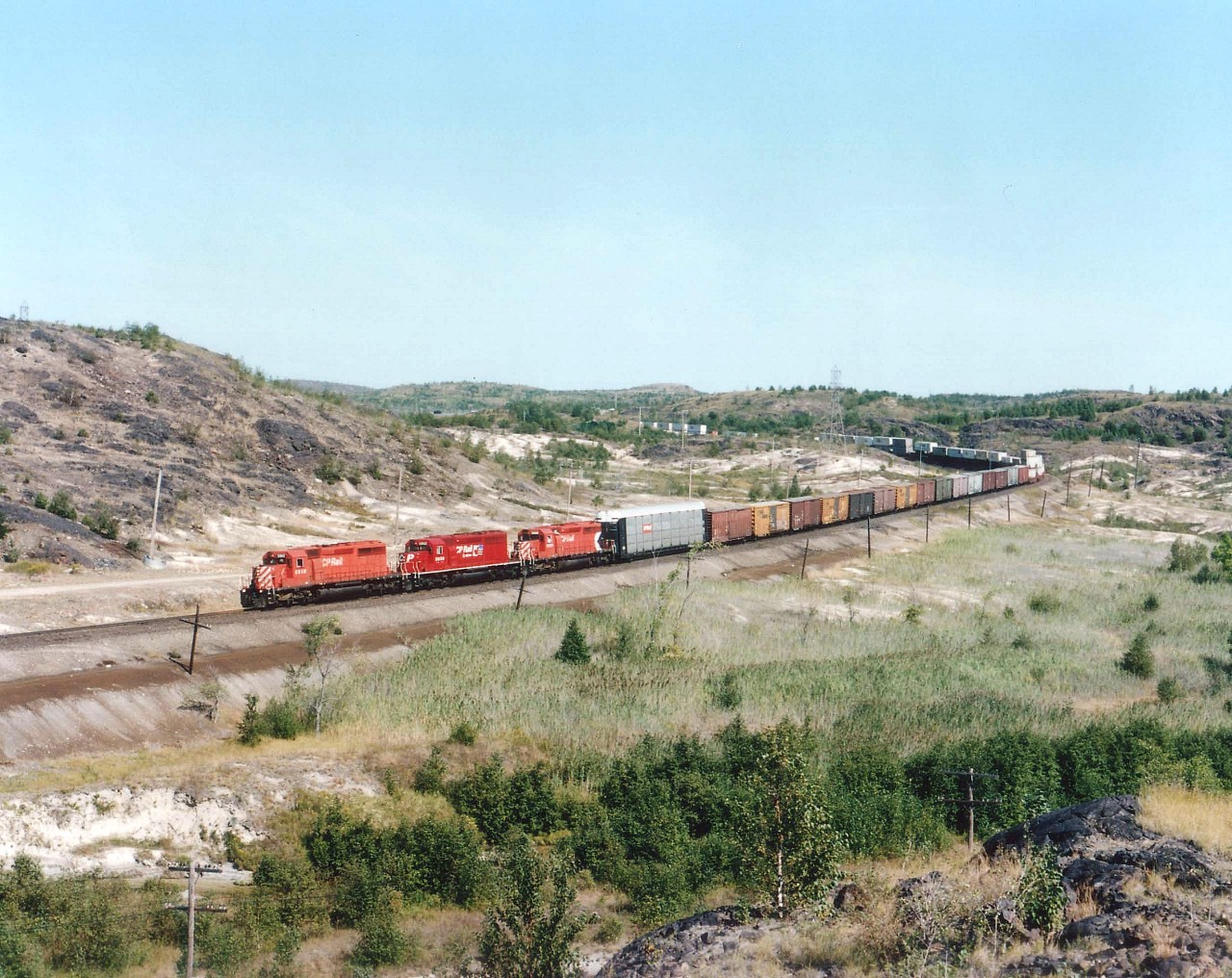 CP 5910, 5950 and 5928, each sporting a different CP paint scheme, power a train westbound from North Bay. This route is no longer well patronized due to the well-documented demise of the main CP line east of Mattawa down to Smiths Falls, ON.  All mainline trains now routed by way of the Parry Sound sub toward Toronto, the junction of which is about a mile west of here.