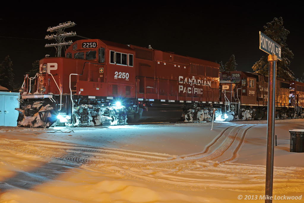 The usual brief stop in town to grab a hot coffee allows for a few time exposures of CP 2250. The snowmobilers go about their business unimpressed by the passage of T07, making good use of the early, deep snowfall up here on the moraine. CP 2250, 3105, 2254, and 8206 lead 24 cars. 1916hrs.