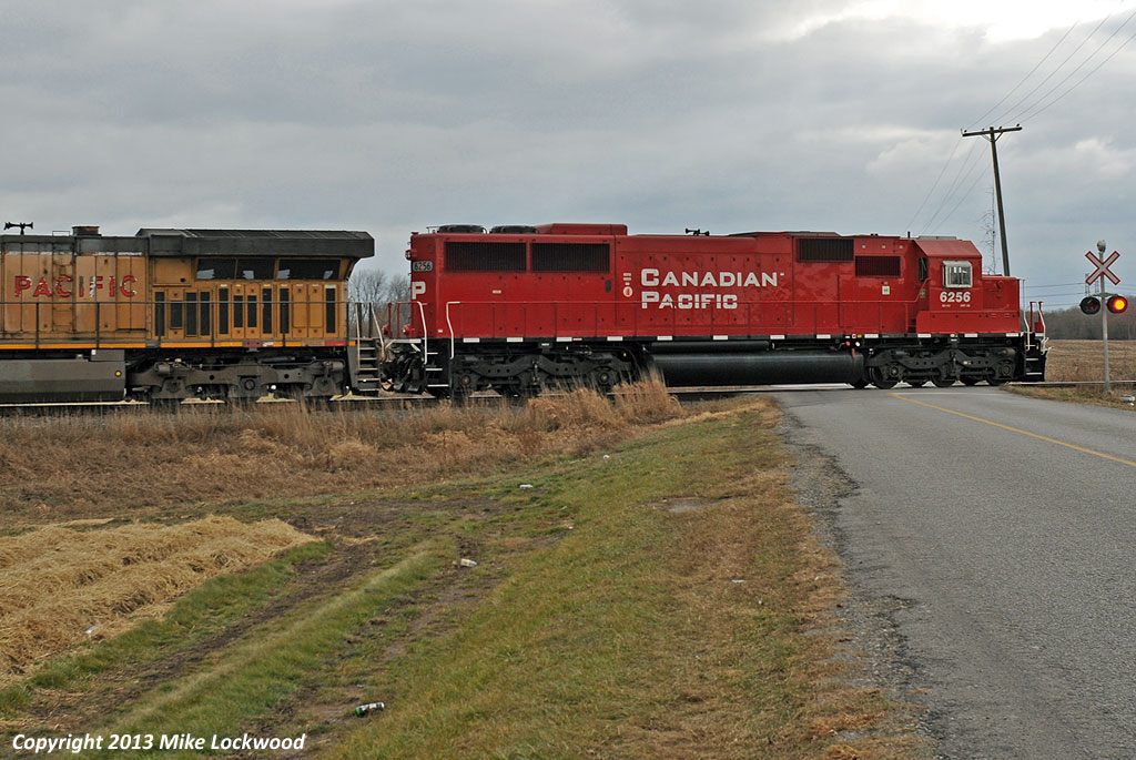 CP 6256 hits the crossing of Maple Grove Road as it leads UP 6937 and 241's train west at Bowmanville, Ontario. 1412hrs.