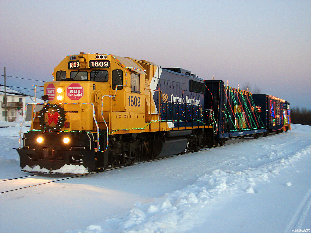 ONT 1809 North with 999, also known as the Christmas train, slowly ambles their way through Moonbeam at last light en-route to a show and stay in Kapuskasing for the night, before continuing onto Hearst the next morning during the 2013 Christmas train tour!