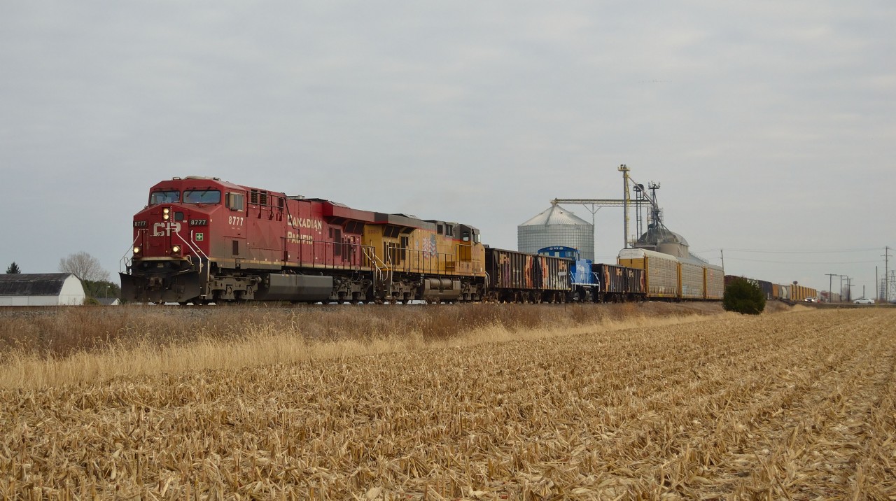 CP 243 led by CP 8777, UP 5550 and CIT 1565 set 3 cars behind the UP, passes westbound thru Haycroft after just passing the Co-op grain elevator.