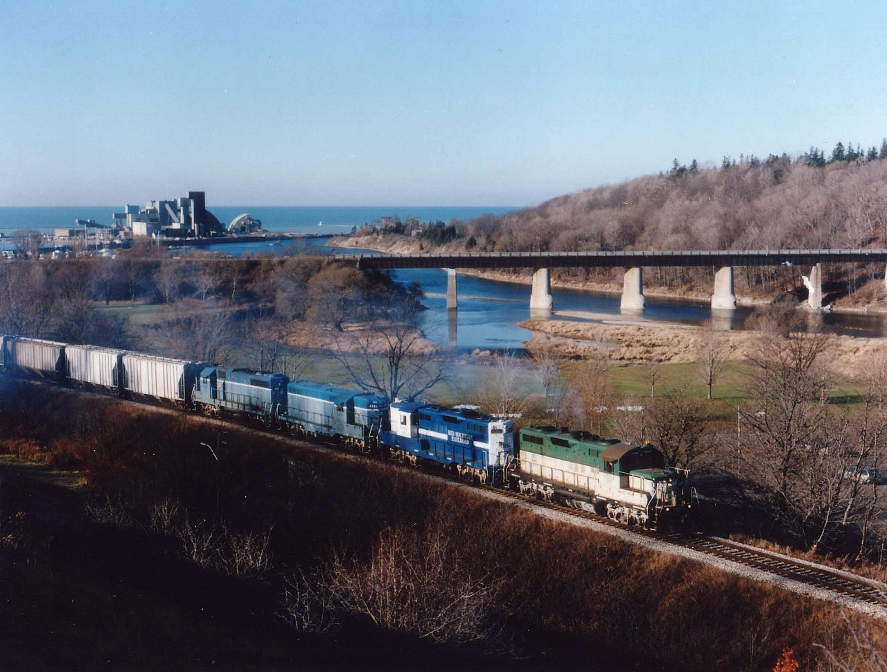GEXR 177, MMRR 5967 and GEXR 4161,66 pull a cut of salt cars up from the Siftco Mine (seen on the far left)up the stiff grade toward the station and yard area. The grade is difficult enough that more than one trip up to the yard is required to bring cars for the train which, once together, is taken south to Stratford. This power consist is 2 GP9s up front, with a GP-7 Slug and "Mother" trailing.  
The 4161 was scrapped in 2008 and the #66, renumbered 3834, sold to a broker in 2011.