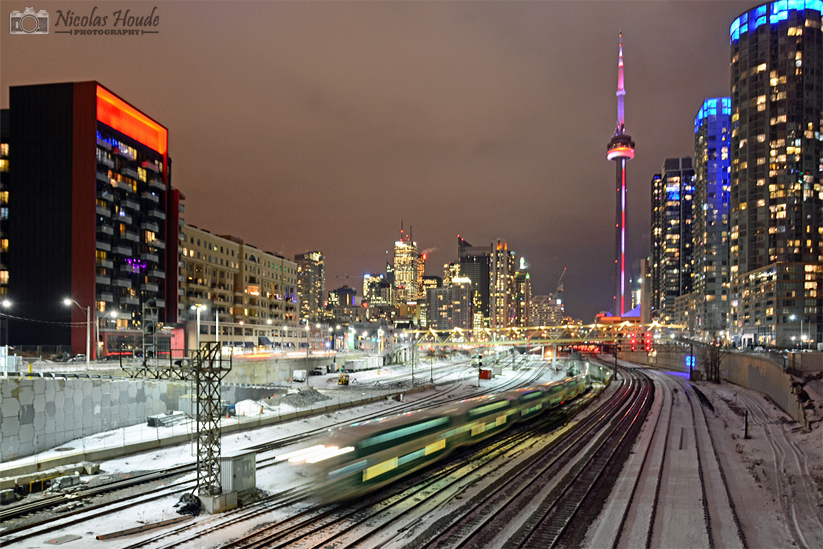 Merry Christmas! By a frosty evening, an outbound pass under Bathurst St. in front of Toronto city, and the CN Tower in background.