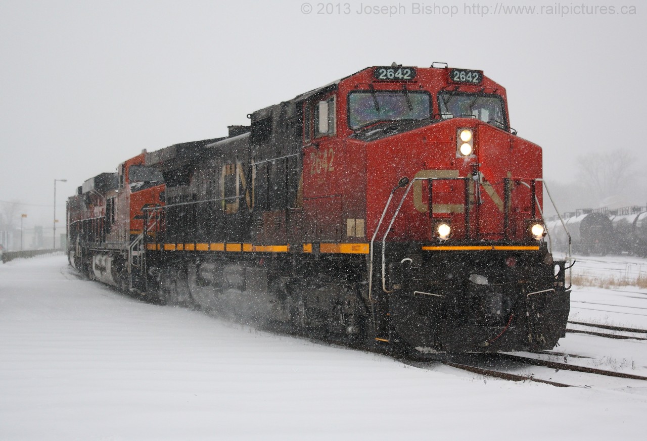 CN U710 slowly passes through Brantford amid a snow storm that dropped 15-20 cm of snow in some places.  Providing the power is CN 2642, BNSF 7061 and BNSF 1005.  I was lucky to get this train, I had an exam at 3:30 and upon finding out about the two BNSF's trailing we set off early to get into Brantford in time to see it.  As we pulled into the station parking lot, the train came around the bend.  Talk about good timing!