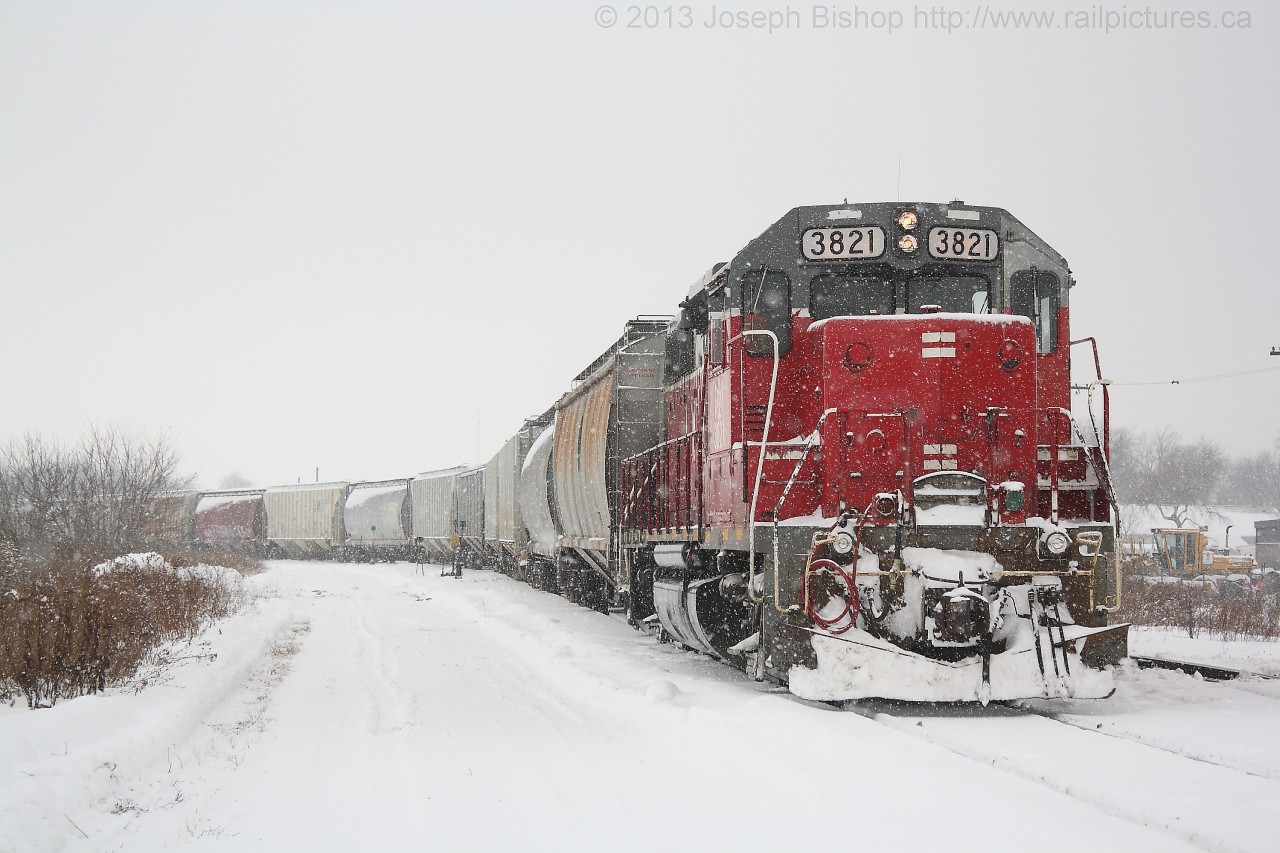 GEXR 516 with GEXR 3821 providing the power shoves hoppers into the East end of the yard in Stratford during a snow squall.