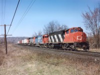 In the late 1980s for a time the CN ran something called the LASER, a dedicated daily trailer train, which I saw mostly using well cars, originating in the Toledo area, and running to Montreal. I'm fuzzy on this, so could use clarification/correction from any CN guys out there........ The service, like many othre brainstorms, didn't last long. The neat feature of this train was it was often seen with GT or DT&I power mixed in, sometimes even DT&I leading; or perhaps a set of 3 GTs!! In later years I would see it with only 2 units. This image was shot on a nice warm April morning from a favourite location on a gentle curve between York Rd and Old Guelph Rd in Dundas, lets call it Dundas Mile 1.5. I walked in from Mile 2 to park my butt here and spend a few hours. Power this day was an 'ordinary' CN 9511, GT 6400 and CN 9403.