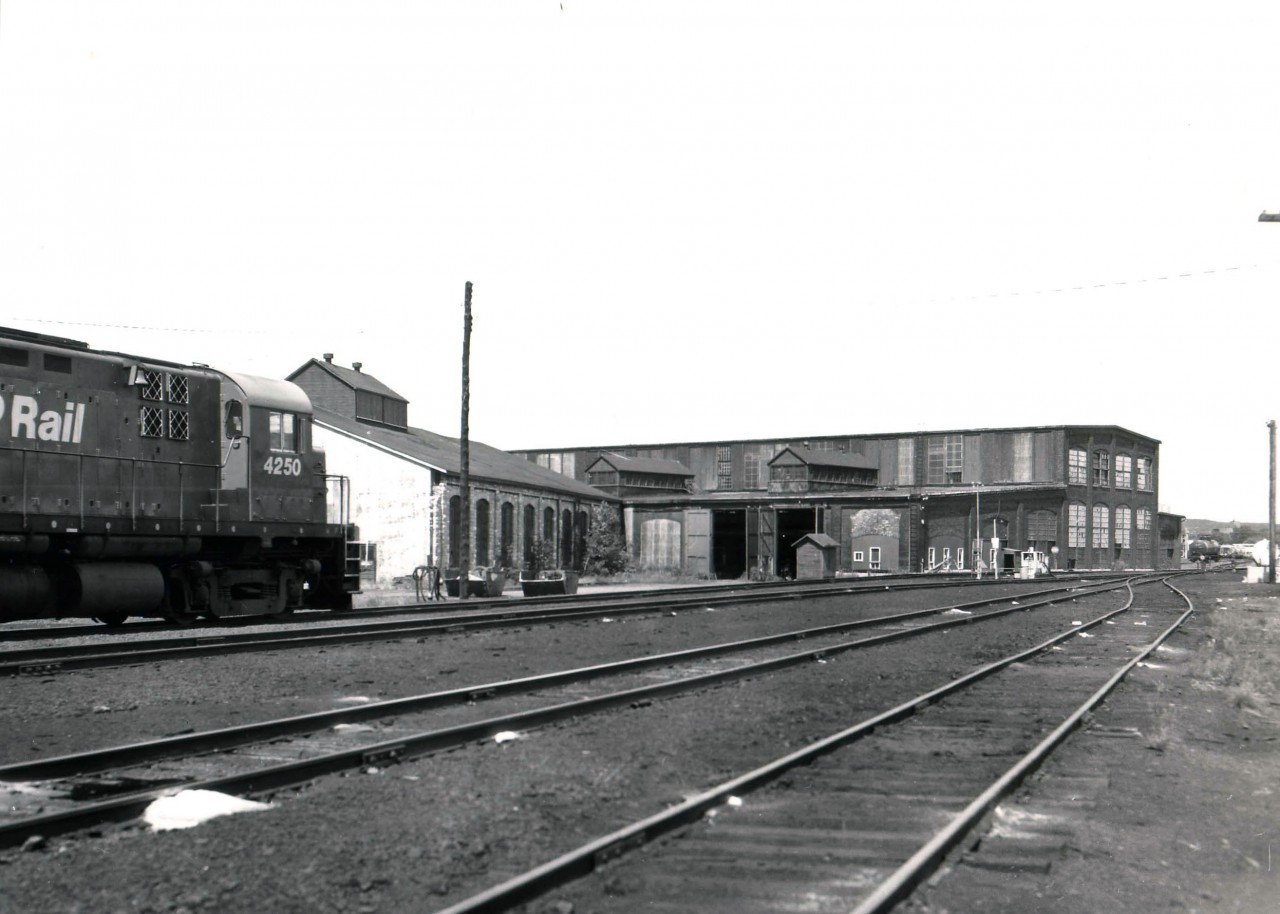A visit to North Bay, ON in the summer of 1987 found the CP shop buildings almost deserted, making an almost unobstructed photo of the east/south side of the complex possible. I'm not exactly sure of the location on the 'locator map' but just took a stab at it and would appreciate being corrected. I understand the shop buildings came down in the 1990s to free up land for the complete development of a waterfront park on Lake Nipissing. Ottawa Valley now operates the CP trackage in an agreement @1996, tracks relocated west of old CP main, away from historic CP station, and there a small yard in town. Extensive residental/commercial/park redevelopment of the old CPR lands has taken place. (Currently the parks development alone, at $7.8M, is overbudget.)