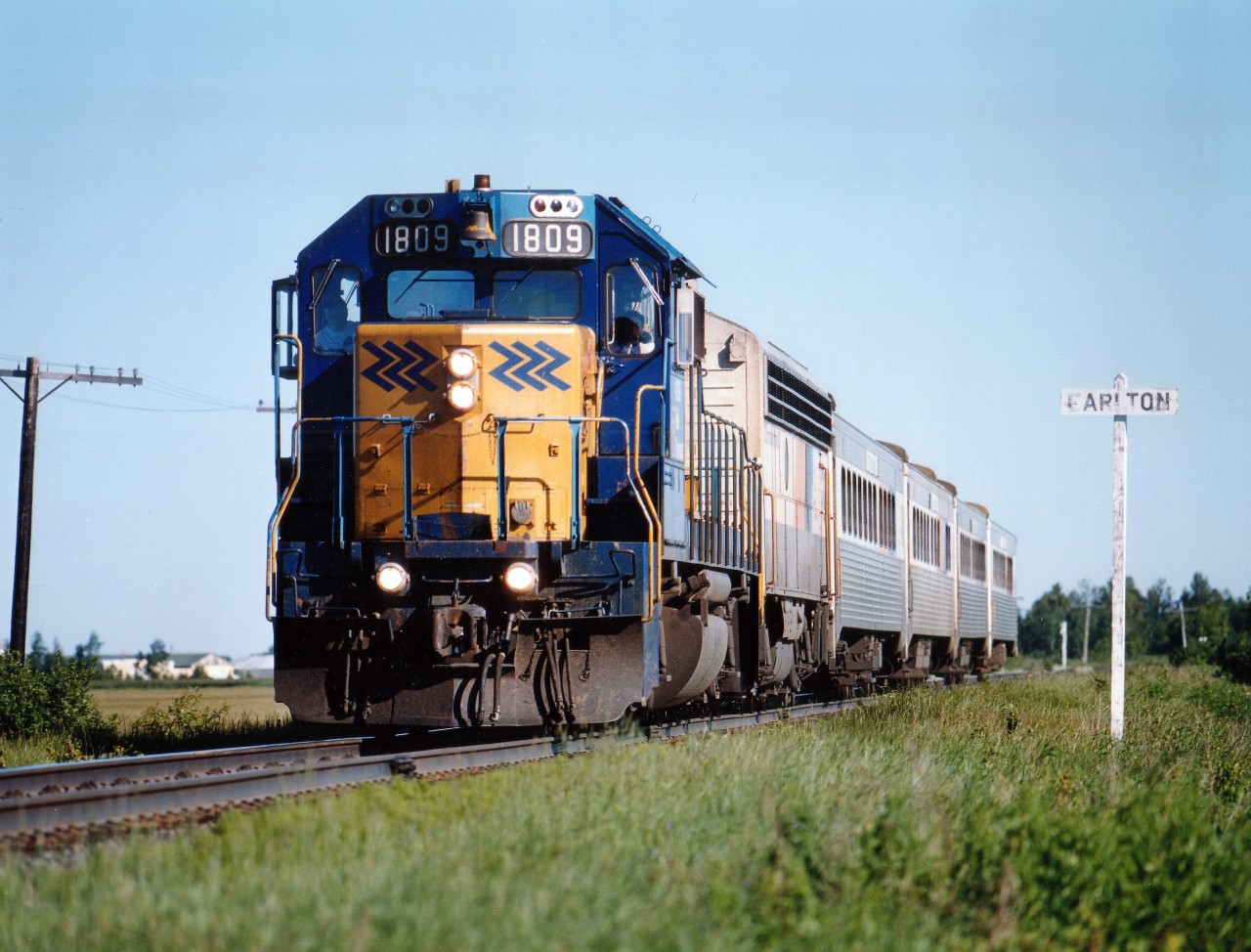 Gone, of course, but not forgotten. Chopped and Diced by the Liberal Party.  The Southbound Northlander train #122 is shown here with the standard consist of 4 cars and "B" ONR 203, auxiliary power unit, behind the ONR 1809. Photo approx. 0830 provided nice low sun angle. First time visitors to Earlton area are often surprised by the nice farmlands, similar to the Ontario southwest.