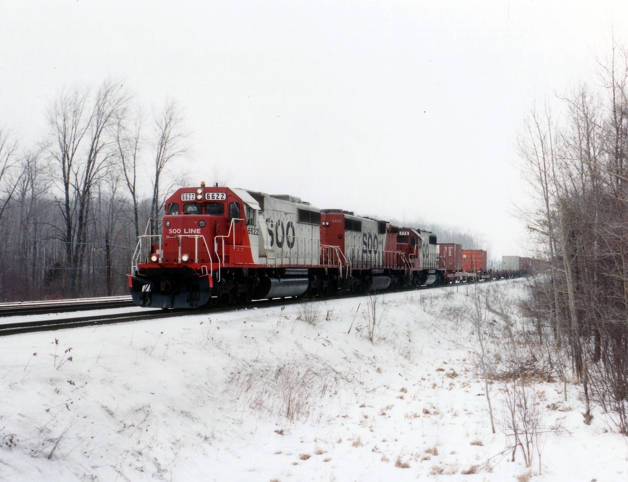 You can't really see it in the photo, but this was one of those days where the temperature hovered around freezing, the roads slick, drizzle, ice pellets and mist so aggravating; all conditions right for a decent sighting. Second train of the day after arrival at First Line, just to the west of Guelph Jct. is this SOO lashup with 6622, 6450, and 775; the middle unit that elusive one of a kind "B" unit.