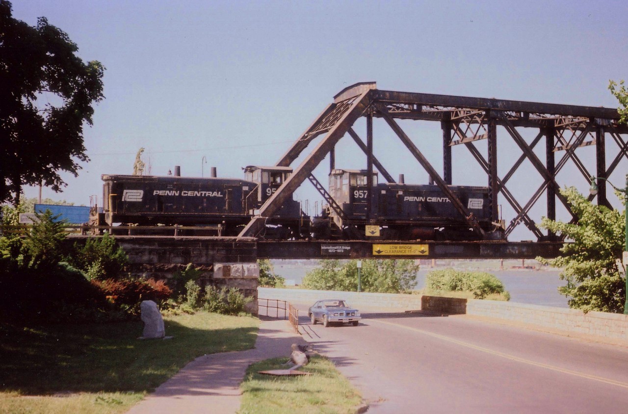 Since the organization of Conrail had taken hold of many of the North-East US's struggling old railroads, it was becoming increasingly difficult to see 'pure' paint schemes of the once-mighty Penn Central any more. This was a lucky catch, PC 9567 and 9576, not yet signified part of the new order with a "CR" stencilled on the carbody.  Note the sun angle. As those who frequent the area would know, late afternoon/evening sun angles were real killers for shooting transfers heading back stateside. So, this shot looking northward as the power runs light on the International Bridge over River Rd. was the only option of the day.