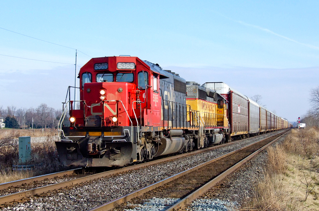 CN SD40-2 5365 and UP SD40-2 3331 bang across the CP Windsor Sub at Melrose with train E27131 04 hauling autoracks from Oshawa, ON to the UP at Salem, IL.