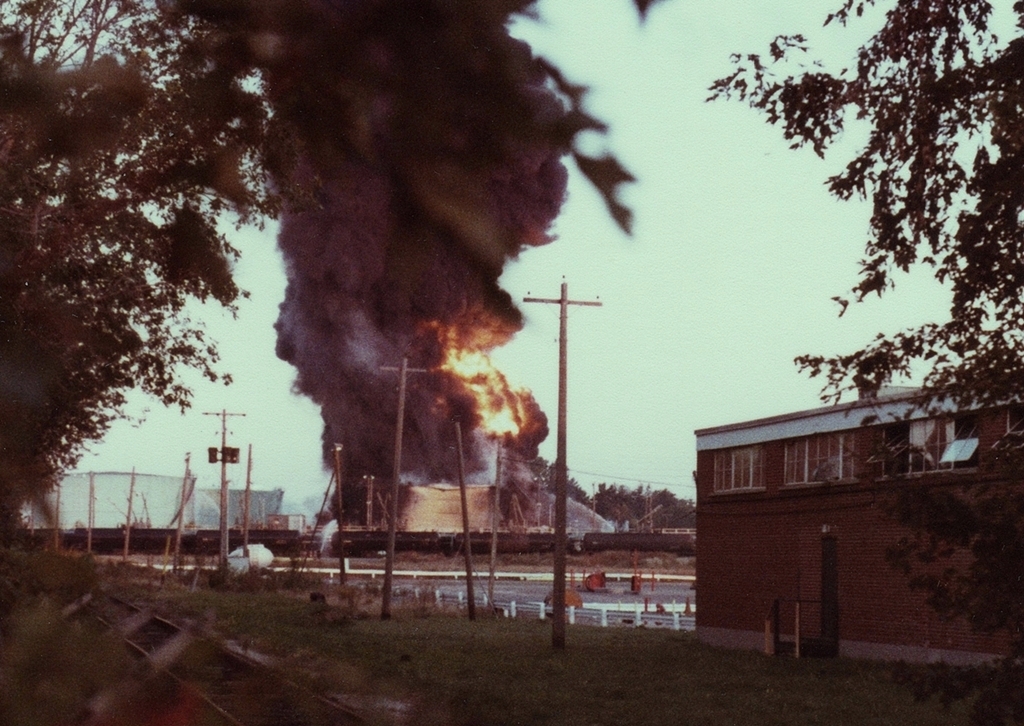 A. W. Mooney's photo and subsequent discussion about the 1979 Mississauga derailment reminded me of another disaster that impacted rail operations (although much less severely) in the Mississauga area a year earlier.On October 2, 1978, a tank of furnace oil caught fire at the Texaco refinery in Port Credit. The cause was arson by a Texaco employee. The proximity of the fire to the CN tracks (immediately behind the line of tank cars)can be seen in this photo, taken from Lakeshore Road at about 8:00 AM the next morning. At lower left is the spur leading to the main refinery complex, which was on the south side of Lakeshore. The building at right was also owned by Texaco. A TD-Canada Trust bank currently occupies this spot.