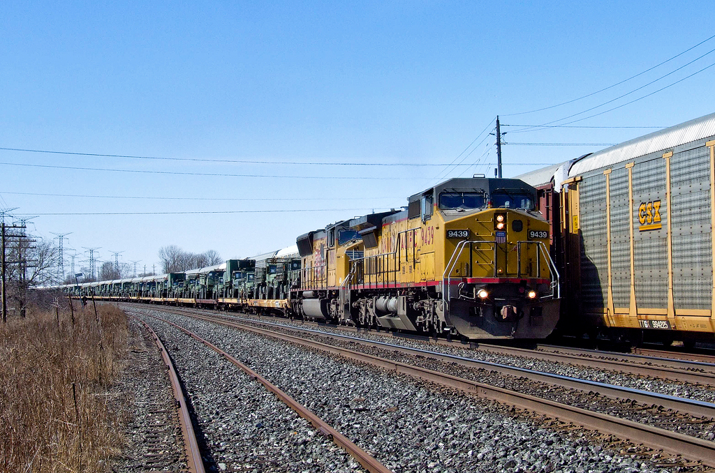 UP C41-8W 9439 and UP SD70M 5109 approach Clarke with UP Salem, IL - Quebec City, PQ military train X35091 09. The military equipment was en route from Fort Bliss, TX heading to Val Cartier, PQ.