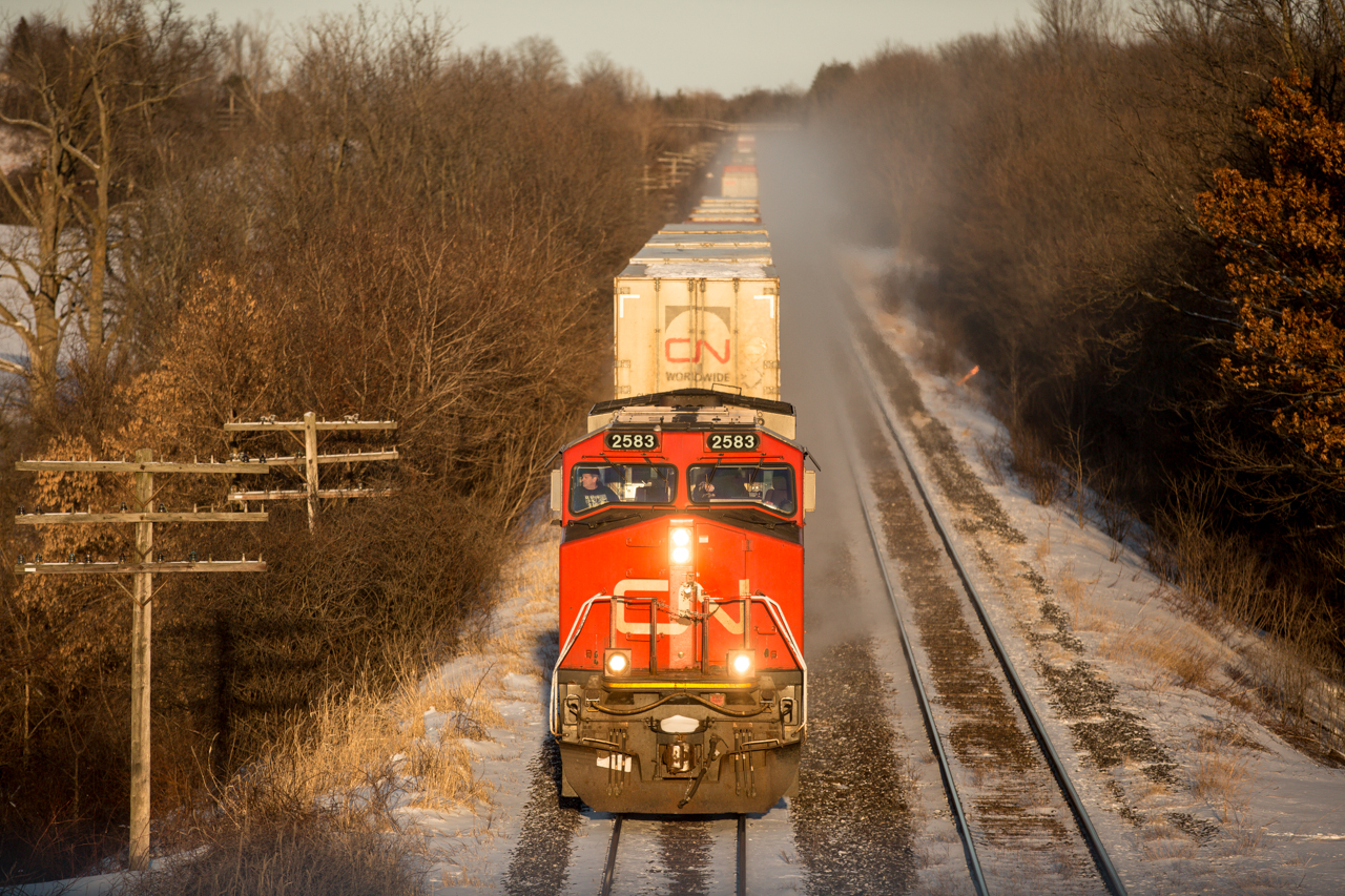 CN 2583 leads an intermodal train west out of #ldnont on the CN Strathroy Sub MP 6.5 as the last few moments of sunlight start to fall behind the horizon