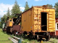 An old retired BC Rail crane rests in a museum in the outskirts of Squamish, BC with a boxcar attaches to it.