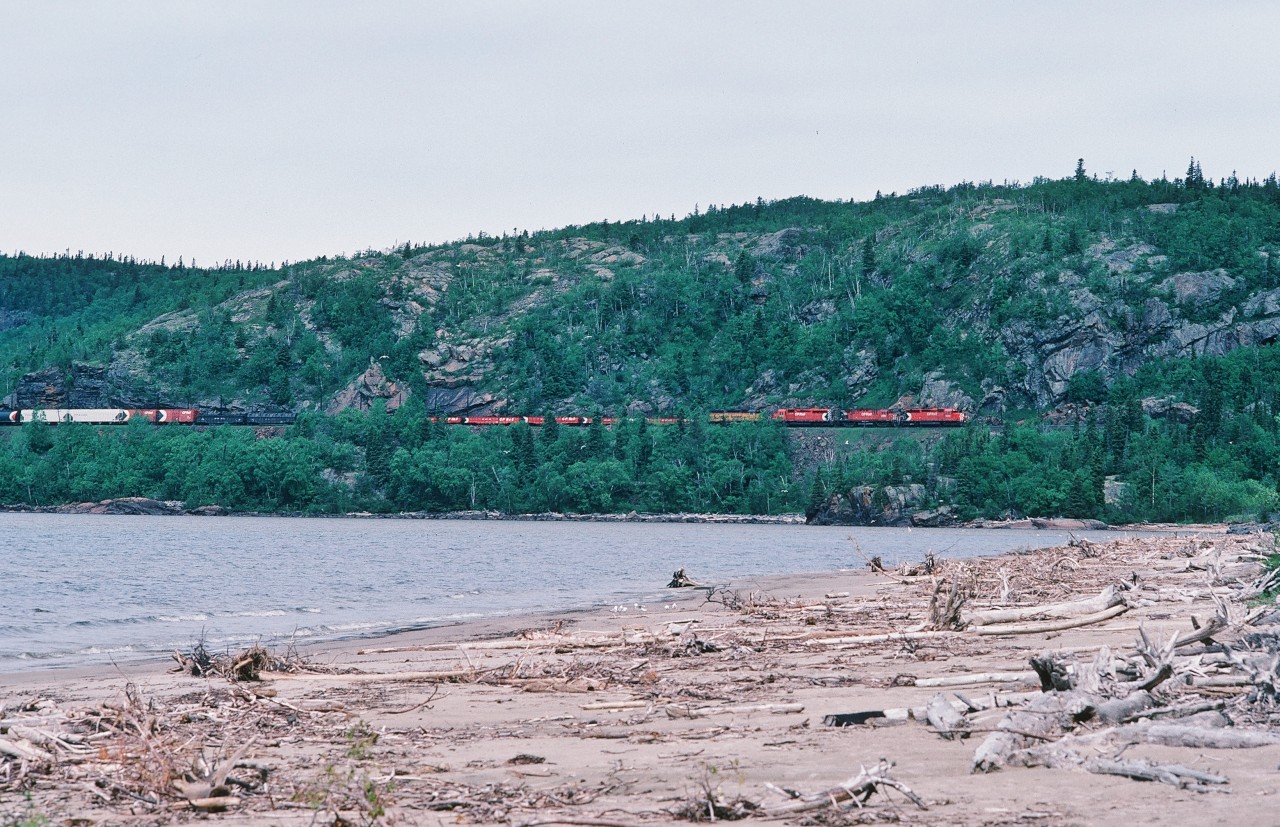 Long live the Multi-mark ! 


 Ah.....Summer North of  Superior.....when track occupancies ( blocks ) limit daylight train operations....where any operating train is a celebration...and when the ubiquitous Chessie units were a staple on CP Rail.


Chris Wilson's 2012 shot at Neys Provincial Park  reminded me of this....


At Neys Provincial Park, standing on a gravel bar at the mouth of the Little Pic River – the viaduct is just around the corner – an eastbound CP Rail ( a division of Canadian Pacific Limited ) powered by a GMD – MLW – GMD – EMD (SD40 – C424 – SD40 – GP40 ) combo crawls along the rock face near mile 81 Heron Bay Subdivision.


June 25 1985  Kodachrome by S. Danko.


 What's interesting: 


Provincial campground near by, so you can try to sleep while clearly hearing the daylight less operations ! 


Look closely, the Rock Fall and Slide Detectors (fence) is visible behind the train.


Chessie: the shortest lived class 1 freight paint scheme? ( 1972 to 1986 ).


 More: Little Pic River at  Neys Provincial Park:


    the lookout  


   track level  


    bridge to bridge  


   river level  


  2014 view  


sdfourty