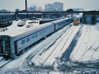 Winter in the City.
<br>
<br>
Once upon a time one only traveled downtown to see the servicing of mainline passenger equipment.
<br>
<br>
The ' Other '  View from the Spadina Avenue bridge.
<br>
<br>
Often – likely mainly – overlooked was the area south of the CNR Spadina Roundhouse.
<br>
<br>
…..and for the modelers: what to do with that area behind the roundhouse.....
<br>
<br>
Here, the (ex) CNR Spadina Coach Yard Shop remains a busy place....
<br>
<br>
...and steam (heat)  still rules !
<br>
<br>
With ' foreign ' (ex CP Rail) passenger equipment.
<br>
<br>
And the Trackmobile is busy with a couple of Budd built (ex CP Rail) sleeping cars.
<br>
<br>
At immediate left the ex CP Rail Abbott Manor sleeping car is the second of two Manor sleepers – possibly part of the consist for Via Rail  train #58 and the car next to the Baggage appears to be a (ex CN )  Dayniter providing the “ VIA 1 “  service on the Cavalier (Montreal overnight train).
<br>
<br>
January 20, 1985 Kodachrome by S. Danko.
<br>
<br>
More Spadina Bridge: 
<br>
<br>
<a href="http://www.railpictures.ca/?attachment_id=12518"> Another 1985 view from the Spadina Bridge</a> 
<br>
<br>
<a href="http://www.railpictures.ca/?attachment_id=1850"> a view of the Bridge </a> 
<br>
<br>
<a href="http://www.railpictures.ca/?attachment_id=1650"> classic </a> 
<br>
<br>
<a href="http://www.railpictures.ca/?attachment_id=1784"> same view different time </a> 
<br>
<br>
<a href="http://www.railpictures.ca/?attachment_id=7277"> contrasting cabs </a> 
<br>
<br>
sdfourty
<br>
<br>
p.s. upper left: that is the base of the CN Tower.
