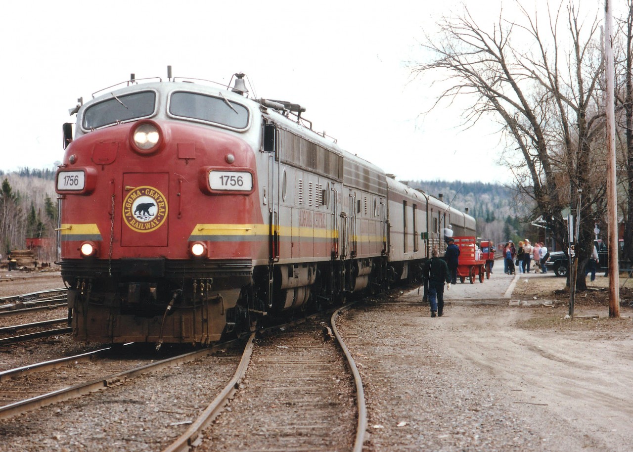 ACR #1 North passenger stopped at Hawk Jct station. Despite the death of the smelter at Wawa, just down the road, and the other assorted blows handed out to the unsuspecting citizens; commerce struggles on. The excitement today, as in most fall days, is centered around the baggage car. Why? Well, if it isn't loaded up with camping equipment and canoes.....and beer, for those heading into the bush, it is loaded with what is so common to us in the South and unavailable in the North. What might that be??  CORN.  Sacks and sacks of corn. Everybody seems to want corn. Corn in the Northern Camps is a delicacy. In Hawk, people anticipated the arrival of the corn like the citizens in days of old awaited the mail. :o) So this day it was 1756 and 1761 to the rescue. Once the Feds kill off this passenger service,(very soon) the favourite amongst the crowds will come by truck at probably 6 or 7 times the cost. And no way to get it to the people.