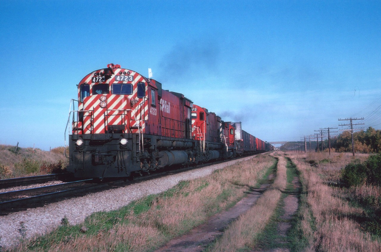 Beautiful afternoon in the early fall as CP 4723, 4702 and 5008 power a westbound across the vast prairie flatlands. Wide load at the head; perhaps construction/mining vehicle?  Not sure of the exact map location, after 35 years I am not up to snuff on my wheatfields. :o)  Want to see 4723?? You can. It is now on display at Farnham, Quebec.