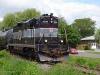 With no more than a bike and a small camera tucked away, a few hours of cycling around Brampton always made for some interesting photo ops. The quiet lull of a lazy afternoon is briefly interrupted as OBRY's (CCGX) 1000 rumbles through one of the neighbourhoods near downtown Brampton, on its afternoon trip from Orangeville to deliver and pick up cars at Streetsville. We're shooting from the English Street crossing north of where the old CN-CP interchange track ends, with the red Corolla turning onto Moore St. in the background. The one pedestrian stopped for the train besides the photographer would give it a casual glance and continue on with their walk after the train passed. What little traffic stopped would soon disperse, and quiet would return to the neighbourhood once more, except for the fading out-of-tune horn of 1000 as it honked for the crossings downtown.