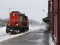 CN GP9RM 7082 trundles long hood forward light power passed the historic Grand Trunk passenger depot in Chatham to fetch its cut of grain cars destined for Blenhiem.