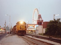 IF you have ever driven on a summer night to downtown Clifton Hill in "The Falls" you know what it is like. Mobs of people and crawling traffic.  I was down that way on a warm summer's eve looking for a chance of catching the evening Chessie (this train came thru earliest at 2050-2100 if I'm lucky) and summer was the only time of the year to get good lighting. Heard nothing on the scanner. I'm coming up to Clifton Hill and, holy (bleep)!!  Its the damn train!!! There is nowhere to park and no time to react, so I put two wheels up on the curb and jumped out. Being almost dark resulted in a very slow shutter speed. Maybe a 30th sec. A lot of wandering tourists and a lot of roadgeeks laid on their horns as they wanted to get to the turning lane I had blocked.......no rush; they had to wait for the train!! This area is a crazy place at best, and when a hundred car train meanders thru at about 10 MPH, it becomes a REALLY crazy place. So, that night, I fit right in. C&O 4291 and 4173 the power. Note it was a double track back in those days. In a few years one track would be taken up, in 20 years it was all gone and tourists could finally wander in peace.