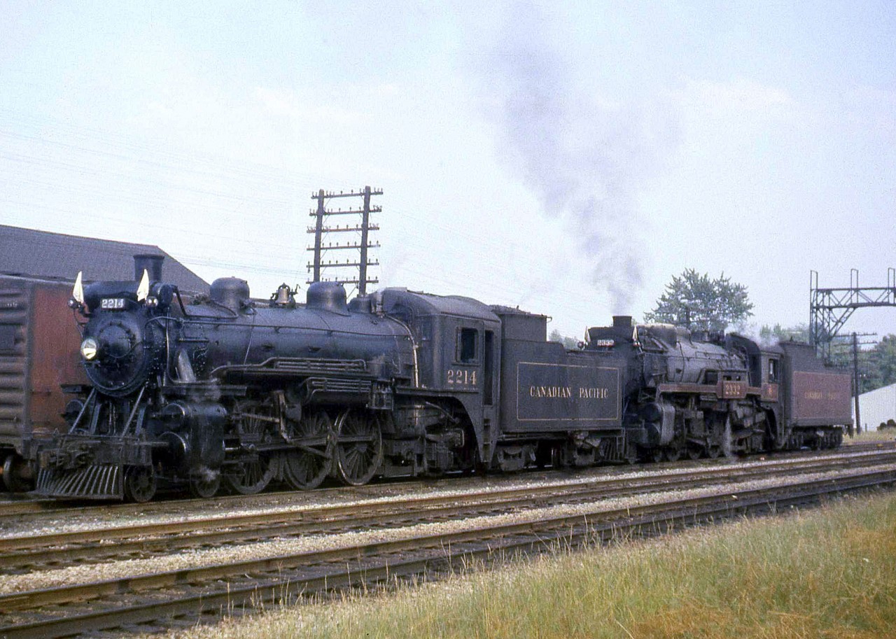 CP G1 2214 and G3 2332 waiting in Streetsville, to take an NRHS fan trip back to Guelph Junction and on to Hamilton in 1959. This trip was well noted at the time as six locomotives were used - two Mikes (2-8-2), two Pacifics (4-6-2, of which the two G-class units pictured were), and two Ten Wheelers (a common nickname for CPR's D10-class 4-6-0 steamers).

[Editor's note: photo likely taken beside the freight shed, which was north of the station site but just to the south of the junction. Image geotagged to reflect this]