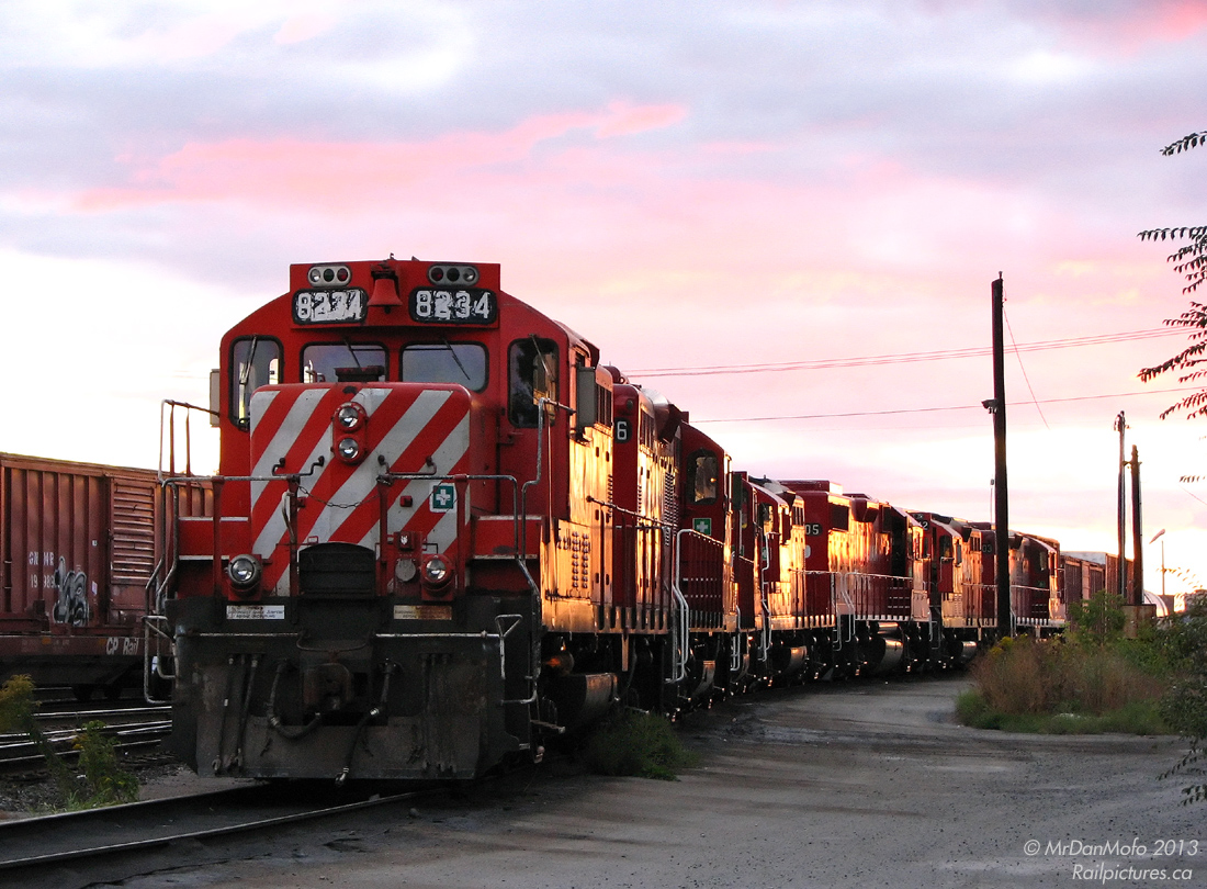 Resting on the "Diesel Spur" in between CP's sprawling West Toronto and Lambton Yards at Runnymede Road, a gang of road Geeps assigned to the Toronto area sit enjoying the sunset together, awaiting to be broken up and sent on the various regular local assignments and jobs. Maybe one pair goes to work the Emery Turn, maybe another is sent out on one of the Obico jobs, or a trip to Mississauga on the Streetsville Turn, or a bunch left together to handle the Lambton Transfer to and from Agincourt.
 Tonight's lashup is almost-all GP9u, consisting of CP 8234, 8226, 8216, 8215, 3105 (a newer GP38-2), 8242 and 8203. Built in the 1950's by General Motors Diesel Division for road service, the 8200's were rebuilt and remanufactured in the 1980's for continued road duties - intended to handle roadswitcher and local work at division points across the system. Just over 5 years later, the literal depiction in this photo would turn figurative, as the sun sets on CP's once-mightly fleet of over 200 rebuilt GP7 and 9's. As of early 2014 they number just over 50 units, with ongoing retirements and scrapping to donate some components to brand new GP30C-ECO units currently being delivered.
Of the old guard pictured, 8203, 8222 & 8234 are listed as Tied Up Unserviceable (likely soon to be retired), 8242 was retired and scrapped not too long ago, and units 8215 and 8216 still active in the Toronto area, for now. 3105, one of a large fleet of newer GP38-2 units built in the 80's (which are being overhauled at contract shops) has since migrated to Winnipeg.