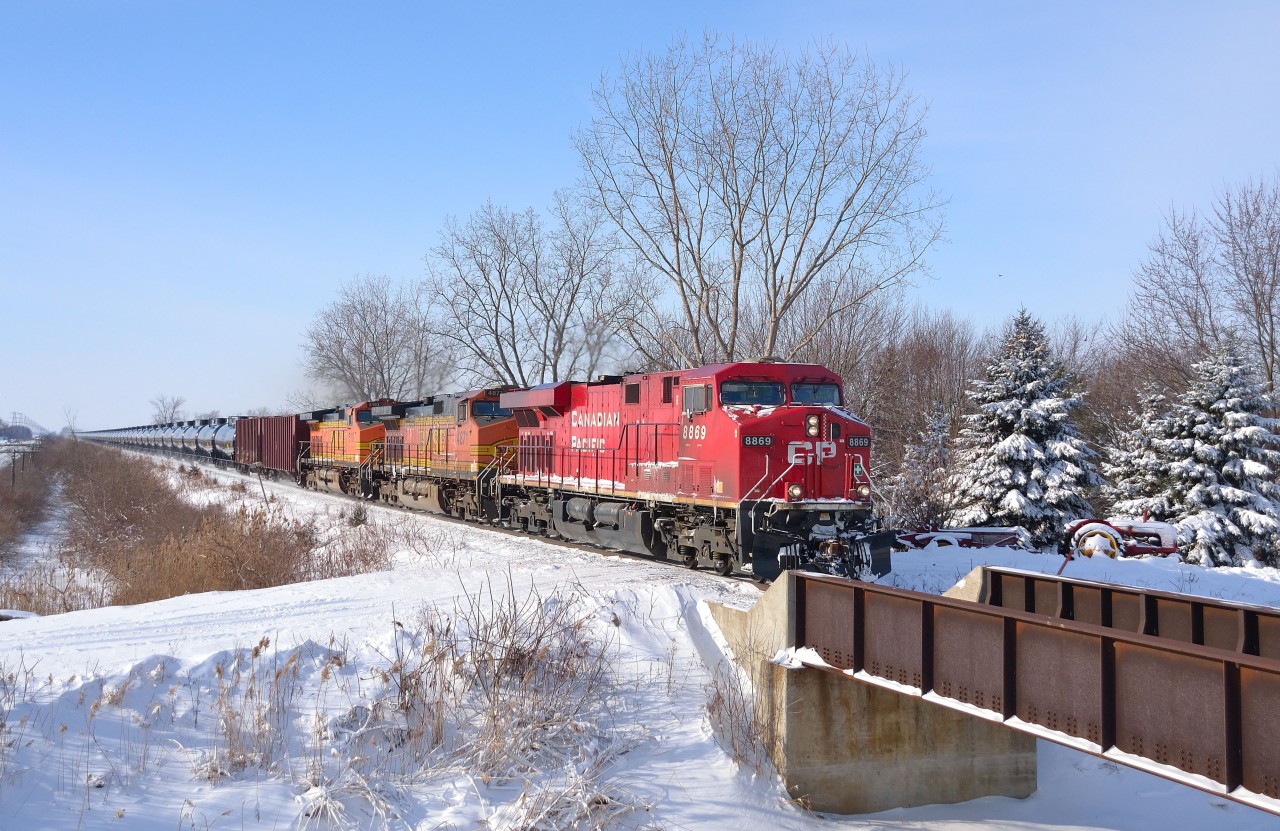 CP 608 led by CP 8869 and a pair of BNSF trailing passes by a farmers crossing on its way eastbound towards London.