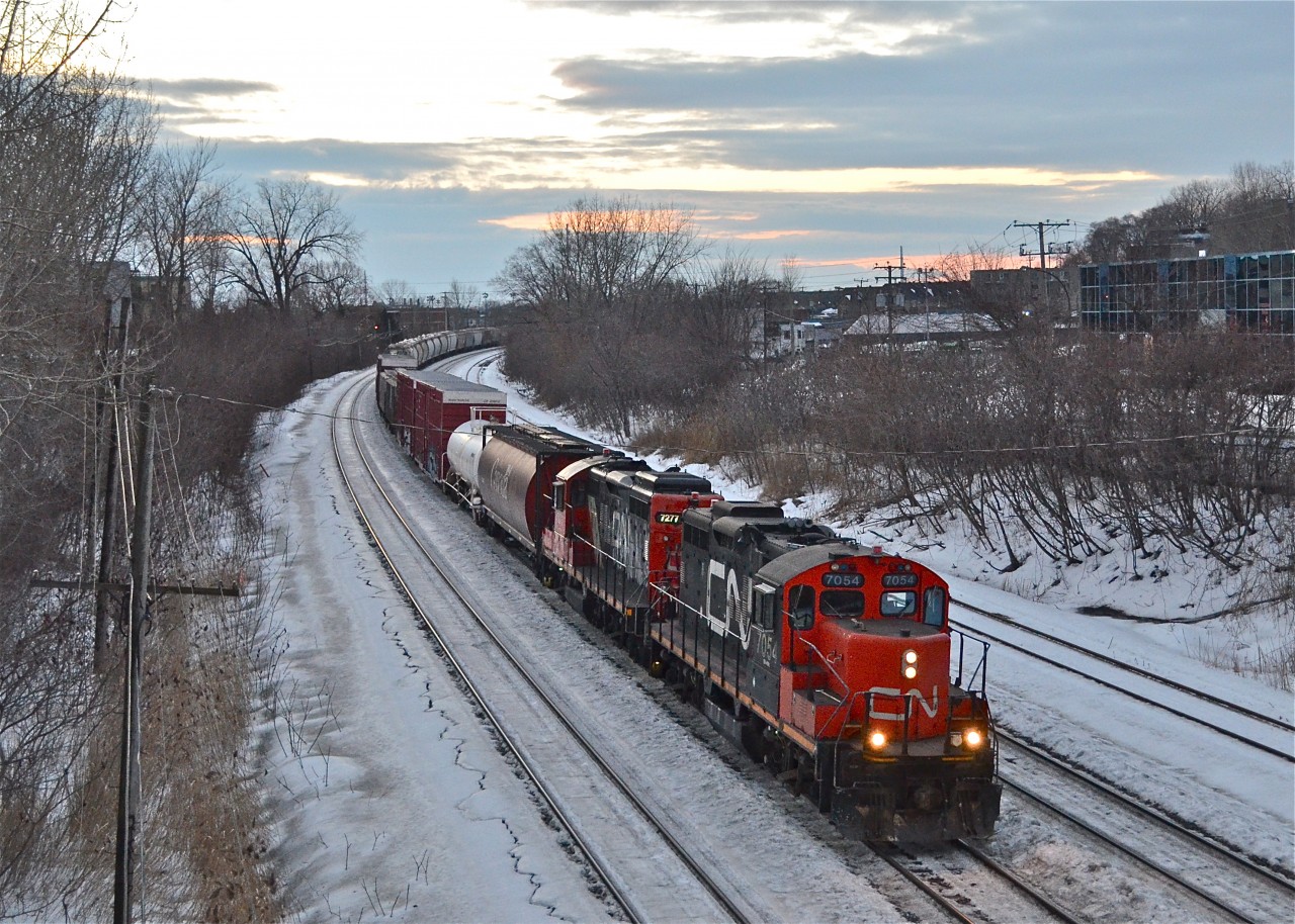 CN 7054 & CN 7277 head east with a transfer at sunset. At the tail end was about 50 empty well cars. A pair of GP9's is not something to take for granted.... though still easy to do in Montreal. For more train photos, check out http://www.flickr.com/photos/mtlwestrailfan/