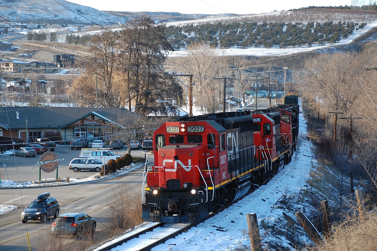 CN(WC)3027 is leading four units as they run alongside Kalamalka Rd in Coldstream and are heading east towards Lavington with a local freight.