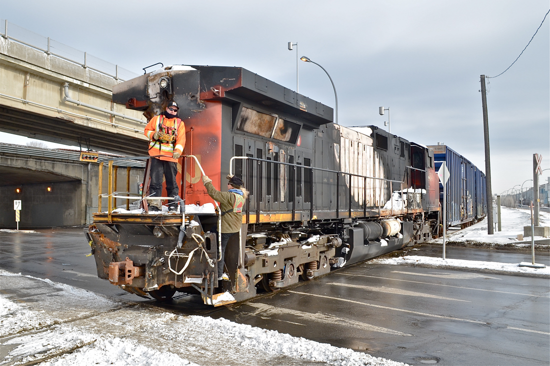 Damaged Dash9! CN 2684 (the DPU on CN 308 which derailed in Plaster Rock, New Brunswick on Jan. 7th 2014) is heading to CAD (Canadian Allied Diesel) in Lachine, Quebec for much needed repairs. One crewmember is boarding the engine after flagging the crossing. They are operating the two GP9's (CN 4102 & CN 7017) which are pushing the train westwards via beltpack. Of note is that this spur which only serves one customer now (CAD) was once CN's main line to the west till a line relocation in 1960. For more train photos, click here.