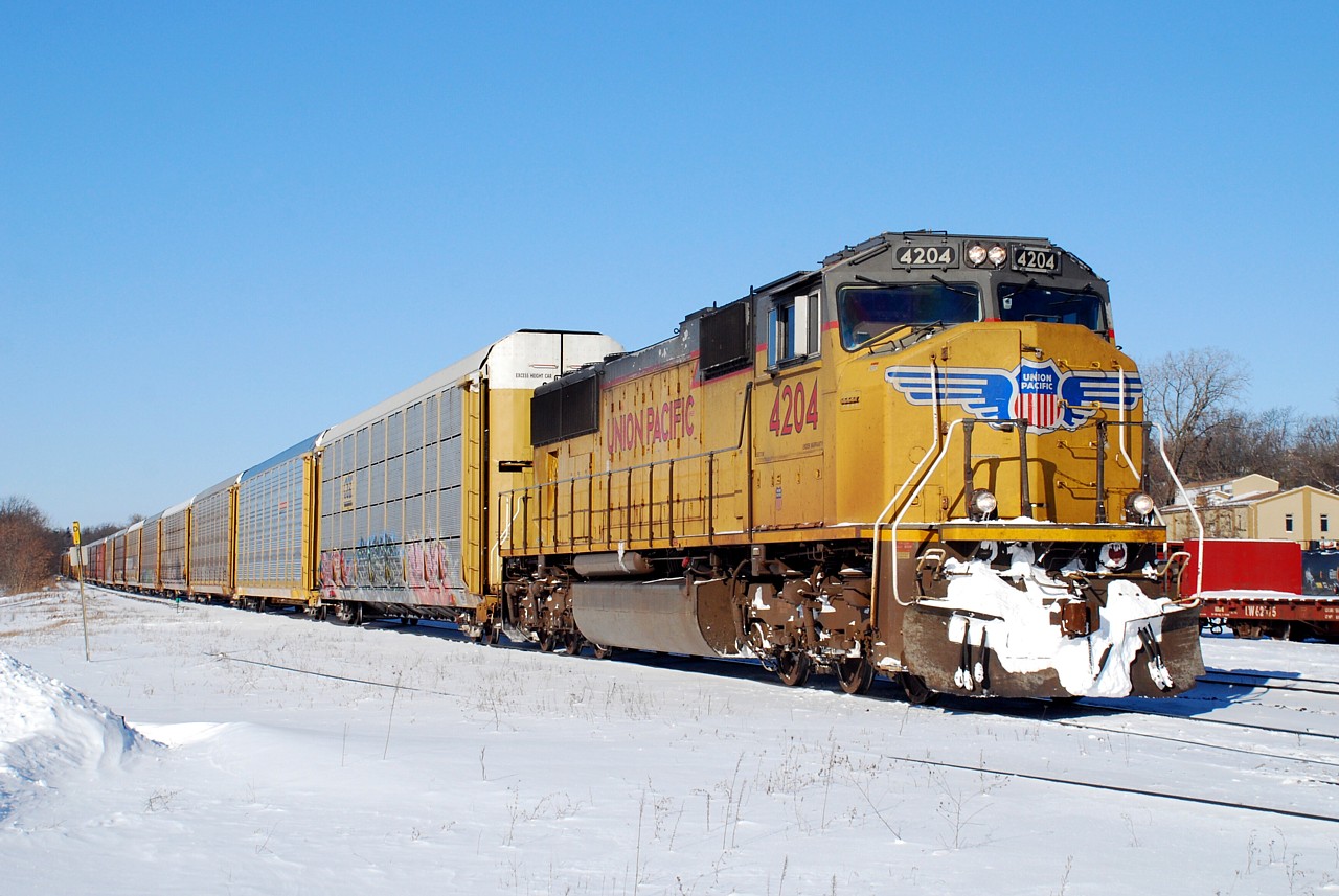 CN 276 with UP 4204 flying solo passes by Brantford yard that was full of action this morning. A crew from Hulcher was rerailing two tank cars at the west end of the yard while a backhoe worked to push the "Air Force 1" snow jet out of a snow pile at the east end of the yard. And for those keeping score, CEFX 2006 is still dead in the yard waiting for wheel work.