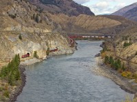 Westbound C.P.R. container train on C.N.R. Mainline. in Thompson River Canyon.  C.P.R. mainline on right side of river, Trans Canada #1 Highway above on left. C.P.R.and C.N.R. share tracks in Thompson and Fraser Rivers Canyons, west on C.N.R. and east on C.P.R.