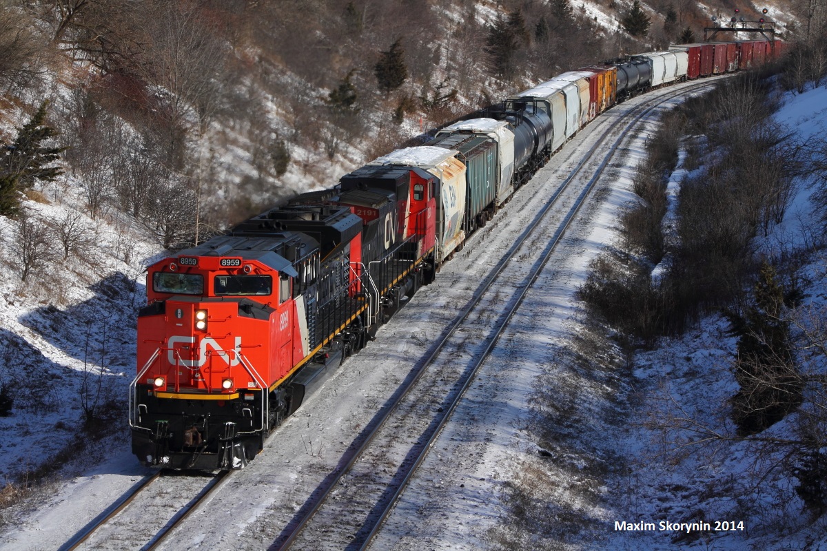 A brand new out of the paint shop bright CN SD70M-2 beast leads a westbound past mile 20 of the York subdivision.