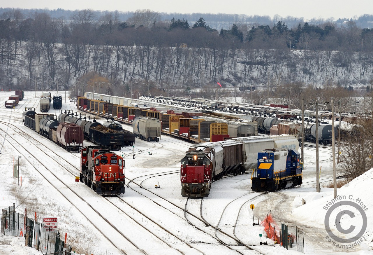 On a dull and dreary day, I get a lucky catch with three working jobs in the SOR/CN Hamilton  Yard. CN 556 has just arrived with a cut of cars and is preparing to return light power back to Aldershot. SOR 494 (Afternoon yard job) is cutting ahead of the day job (SOR 493) as both have work on the N&NW spur in north Hamilton.